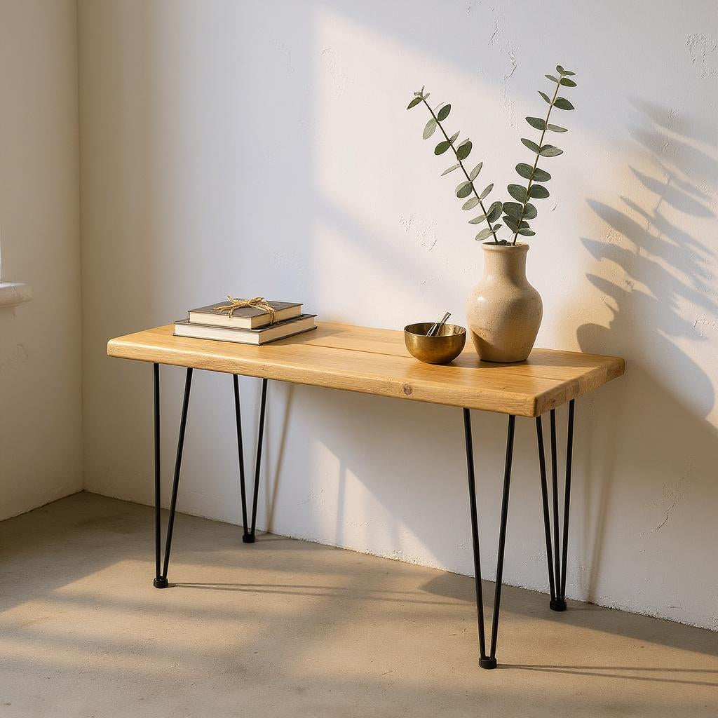 Wooden table with black hairpin legs against a white wall, featuring a vase and books.