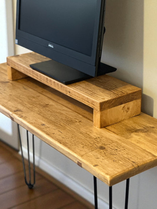 Rustic reclaimed wood monitor stand with black metal hairpin legs, handmade in the UK for ergonomic desk setup