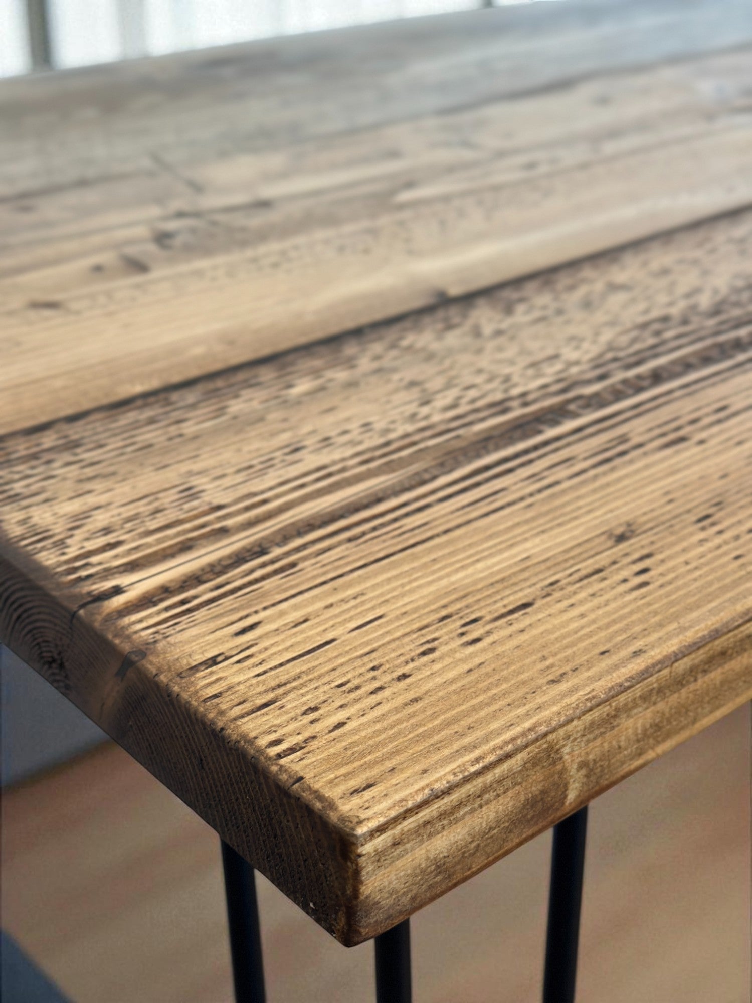 Close-up of a wooden table surface with visible grain and texture.