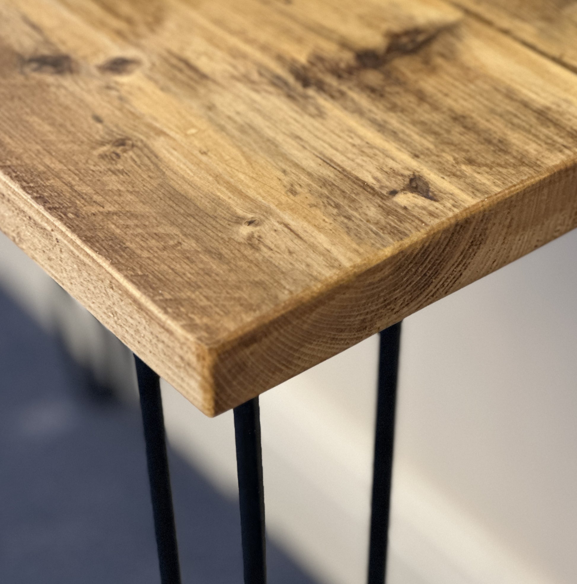 Wooden table with black metal legs on a blurred background